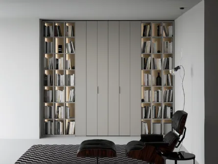 Libreria a giorno lineare e geometrica, in laccato opaco, arricchita dalla schiena in laccato metallico Oxid e impreziosita dall’illuminazione a led passaggio porta di Caccaro